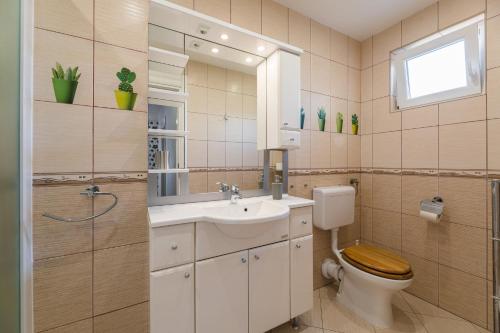 a bathroom with a toilet and a sink and a mirror at NOVOSELIC 7 Penthaus in Dramalj