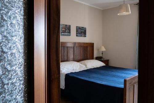 a bedroom with a bed with a wooden head board at Locanda Genzianella in Gargnano