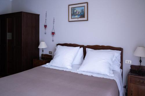 a bedroom with a large bed with white pillows at Locanda Genzianella in Gargnano