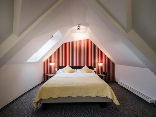 ein Schlafzimmer mit einem großen Bett im Dachgeschoss in der Unterkunft Hotel Engel Business & Lifestyle in Liestal