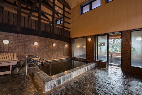 a large bath tub in a room with windows at Ryokan Nushiya in Gotsu