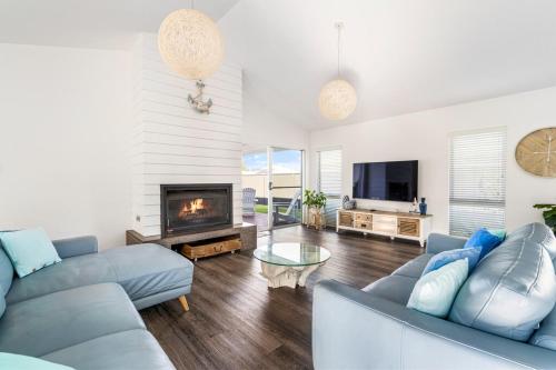 a living room with a couch and a fireplace at Ryze N Shine - Dunsborough in Dunsborough