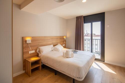 1 dormitorio con cama y ventana grande en Tgna Rambla 68, en Tarragona