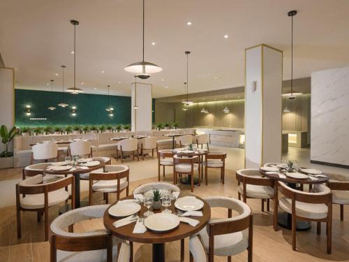 a restaurant with tables and chairs and a bar at Elsotel Purwokerto By Daphna Management in Purwokerto