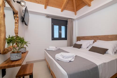 a bedroom with a large bed with white sheets at Azor Luxury Villa II in Zakynthos Town