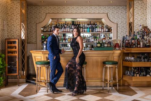 a man and a woman standing in front of a bar at Villa Principe Leopoldo in Lugano