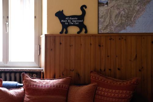 a cat sign on a wall next to a couch at Locanda Genzianella in Gargnano