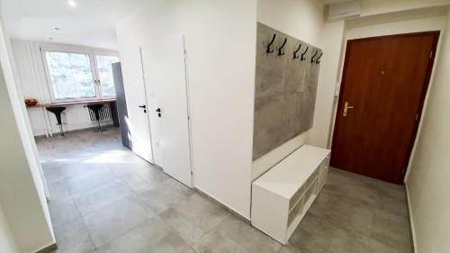 um quarto com um corredor com paredes brancas e uma porta em Apartmán Love Bojnice em Bojnice