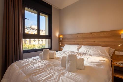 a bedroom with a white bed with a window at Tgna Rambla 68 in Tarragona