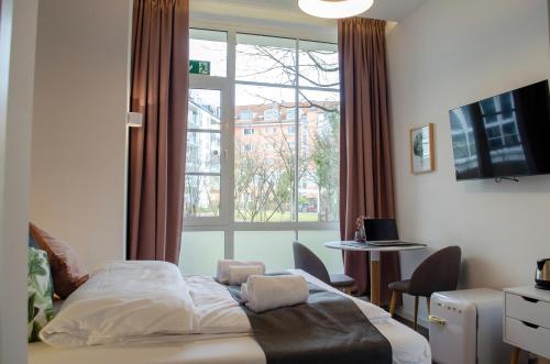 a bedroom with a bed and a large window at HOMELY STAY Studio 8 in Munich