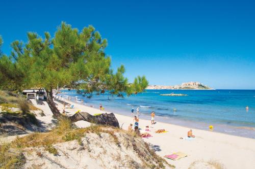 a group of people on a beach near the water at Feriendorf zum störrischen Esel in Calvi