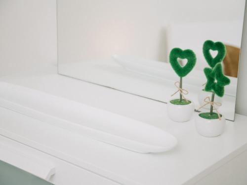 dwa białe kubki z zielonymi sercami na blacie w łazience w obiekcie OPORTO GUEST Cedofeita Terrace w Porto