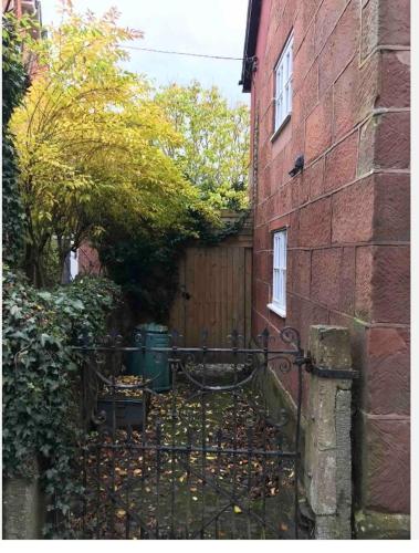 an entrance to a brick building with a iron gate at Pear Tree Cottage Courtyard in Shrewsbury
