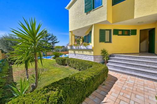 żółty dom ze schodami i roślinami przed nim w obiekcie Villa Oscar, Zadar w mieście Zadar