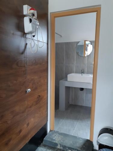 La salle de bains est pourvue d'une porte menant à un lavabo. dans l'établissement Siril Guesthouse Hostel, à Nuwara Eliya
