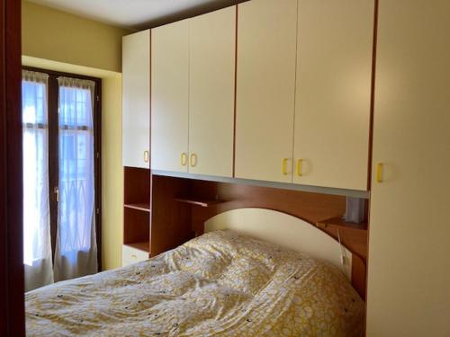 a bedroom with a bed and some white cabinets at Residenza Graziella in Bobbio Pellice