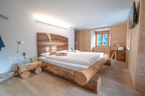 a bedroom with a bed made out of logs at Hotel Wasserfall in Jaun