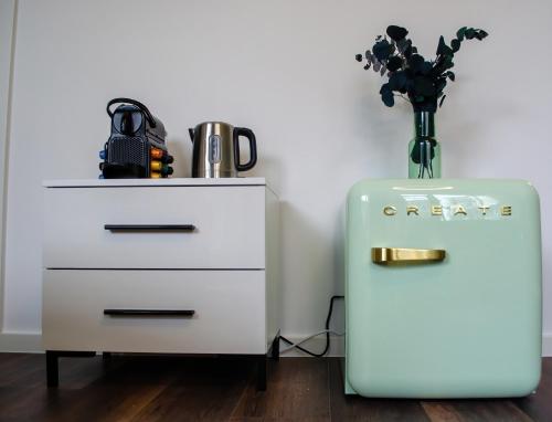 a white dresser with a vase of flowers next to a dresser at HOMELY STAY Studio 9 in Munich