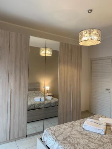 una camera da letto con specchio, letto e due luci di A 10 minuti di metro dal centro a Torino