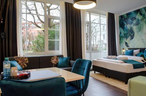 - un salon avec un lit, une table et des chaises dans l'établissement HOMELY STAY Studio 9, à Munich