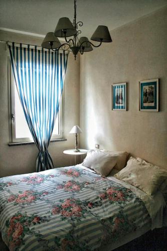 a bedroom with a bed with a blue curtain and a window at B&B Il Bijou in Casalmaggiore