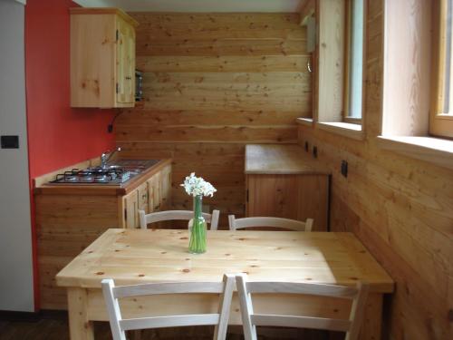 a kitchen with a wooden table with a vase of flowers on it at Casa Pradarèire in Fenestrelle