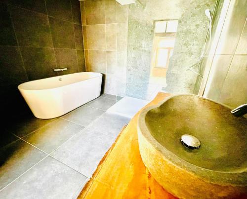 a bathroom with a bath tub and a bath tub at Manoir de Sterpigny, château-ferme 17ème siècle gîte la Tour in Gouvy