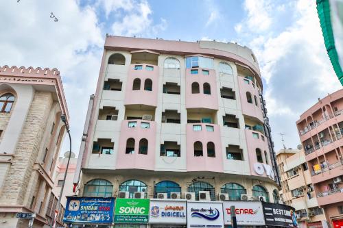 a pink building in the middle of a city at Rahab Hotel in Dubai
