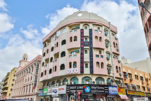 a pink building with a round top on a street at Rahab Hotel in Dubai