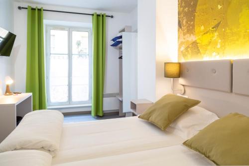 um quarto com uma cama e uma janela com cortinas verdes em Hotel Victoria em Estrasburgo