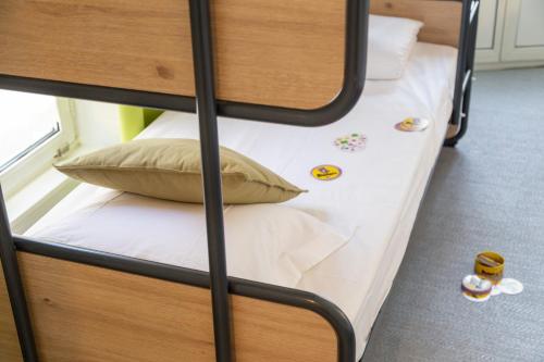 a bunk bed with white sheets and pillows on it at Hotel Victoria in Strasbourg