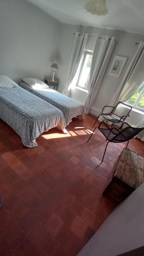 a bedroom with two beds and a table and chairs at RELAIS DES VIGNOTTES in Chevannes