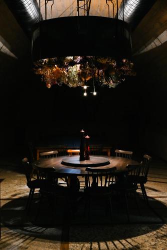 a dark room with a table with chairs and a chandelier at Hotel Buna Mostar in Buna