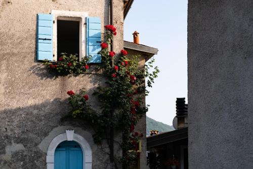a building with a blue door and flowers on it at Locanda Genzianella in Gargnano
