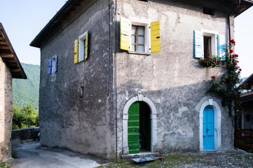 an old house with colorful windows and a door at Locanda Genzianella in Gargnano