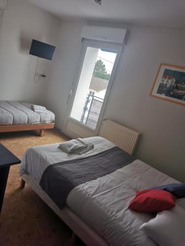 um quarto com uma cama e uma janela em le relais de l aiguillon em Châtellerault