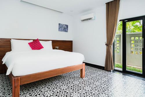 a bedroom with a bed and a large window at Kampot Sweet Boutique in Kampot