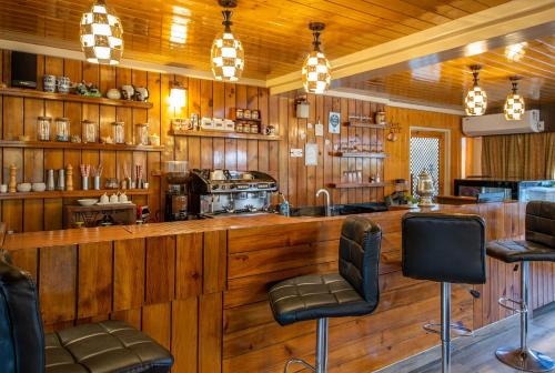 a bar in a restaurant with wooden walls and chairs at The Orchard Retreat & Spa in Srinagar
