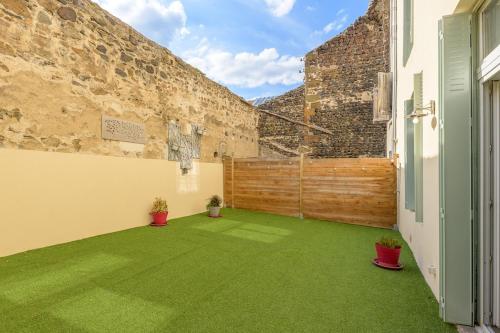 an empty courtyard with green grass in a building at Les Nuits d'Anis - Appartements Hypercentre in Le Puy en Velay