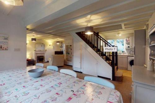 a dining room with a table and a kitchen at Tudor Cottage Hayle - a Family & Pooch Favourite in Hayle