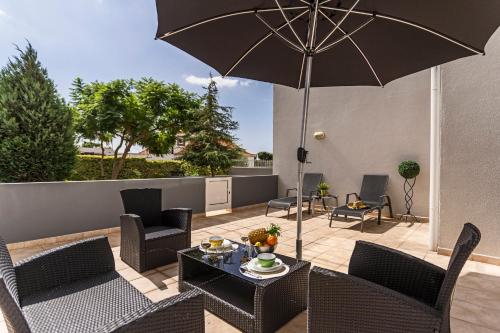 a patio with a table and chairs and an umbrella at Achada I by An Island Apart in Funchal