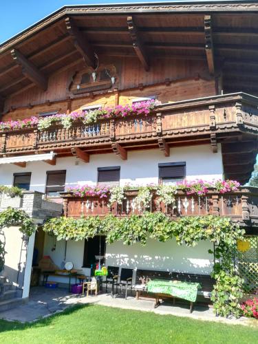 a building with a balcony with flowers on it at Ferienwohnung Familie Fiechtl in Fügenberg