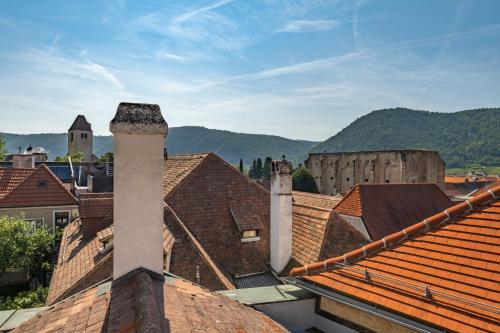 a view of roofs of houses with mountains in the background at Pension Altes Rathaus in Dürnstein