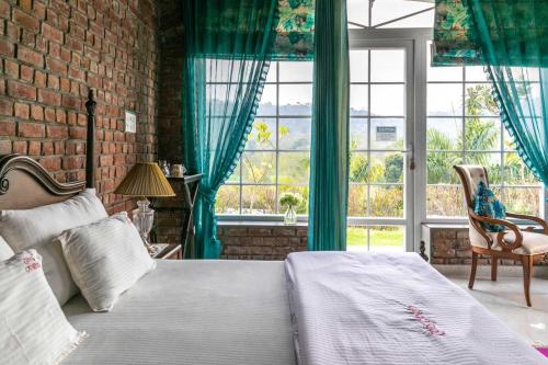 a bedroom with a bed and a brick wall at StayVista at Brickwood Hill with Outdoor Infinity Pool & Jacuzzi in Chandīgarh