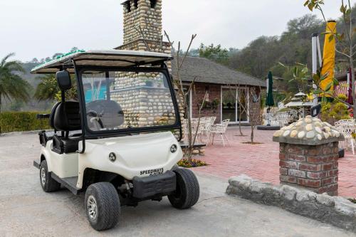 a small white golf cart parked next to a building at StayVista at Brickwood Hill with Outdoor Infinity Pool & Jacuzzi in Chandīgarh