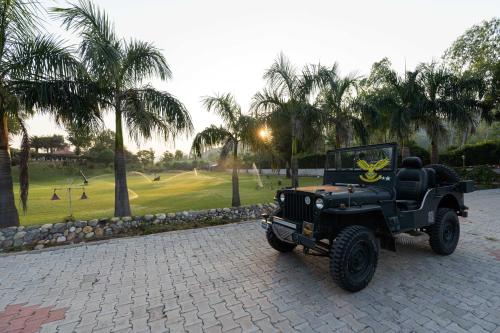 a black jeep parked on a driveway with a golf course at StayVista at Brickwood Hill with Outdoor Infinity Pool & Jacuzzi in Chandīgarh