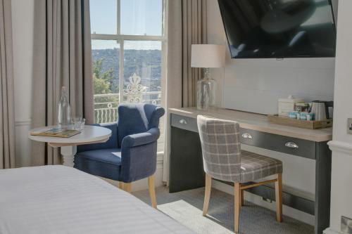 a hotel room with a bed and a table and chair at Lansdown Grove Hotel in Bath