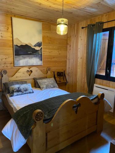 um quarto com uma cama num quarto de madeira em chalet au pieds des pistes le cambre aze em Bolquère - Pyrénées 2000