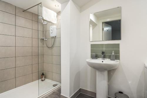 a bathroom with a sink and a shower at The Renfrew Residence 4-bedroom, city centre in Glasgow