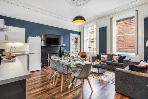 a kitchen and a living room with a table and chairs at Renfrew Residence Central Glasgow 4-Bed Flat in Glasgow